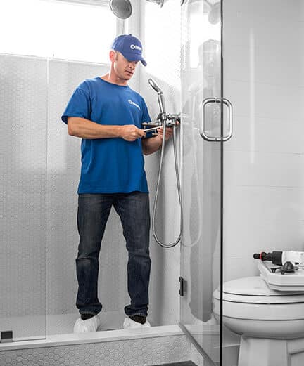 craftsman installing new plumbing fixtures in shower