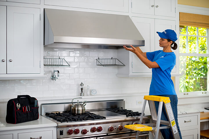 handyman installing kitchen hood